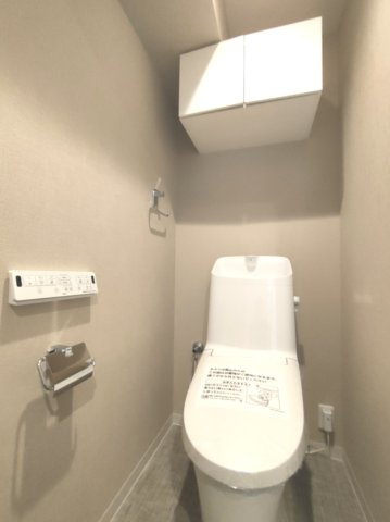 【トイレ】　温水洗浄便座・壁付けリモコン付き。吊り戸棚を備えた機能的なトイレです。