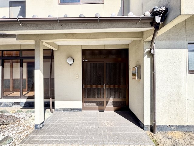 落ち着いた雰囲気の玄関アプローチ。屋根付きの玄関ポーチとなっており、雨の日でもゆったりと出入りができます。格子デザインの玄関扉が和の雰囲気を感じさせ、住まいの印象を上品に演出。