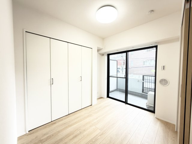 白を基調とした明るい室内と大きな掃き出し窓が開放的な空間。ナチュラルな木目フローリングが心地よく、毎朝気持ちの良い光の中で目覚められます。