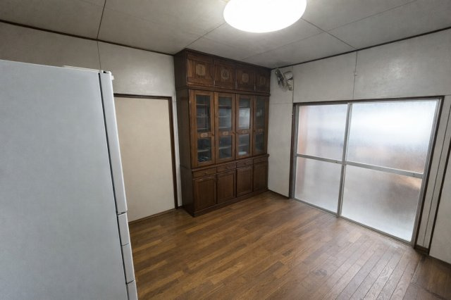 木の温もりを感じる床と大容量の食器棚が印象的なダイニング空間。収納力が高く、食器や調理器具をすっきり整理できます。掃き出し窓からの光も入り、日中は明るく快適に過ごせる居心地の良いスペースです。