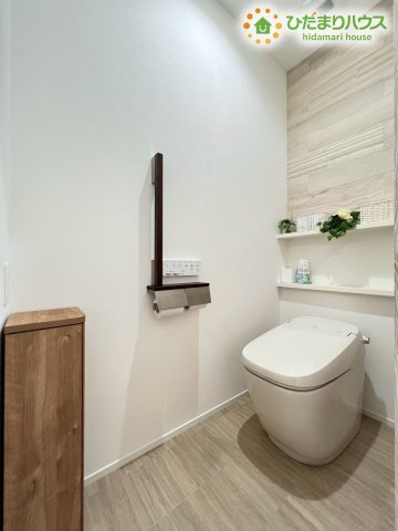 木目調のアクセントウォールがおしゃれなトイレ空間！タンクレストイレは見た目がスッキリしているだけでなくお掃除がしやすいのも嬉しいポイント♪予備のペーパーを置ける棚や手すりも付いていて利便性もバッチリ！