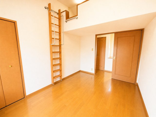 ロフト付き洋室を別角度から撮影した一枚です。居室部分とロフト空間を組み合わせることで、限られた空間を有効活用できる設計となっています。ロフトは季節用品や趣味用品の収納場所として便利です。