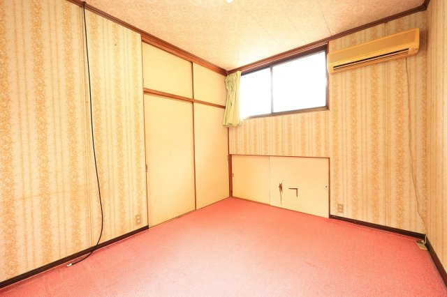 ピンク色の絨毯がどこか懐かしい、2階西側の洋室です。エアコン付きで季節を問わず快適。押入れタイプの収納や足元の地袋収納など、スペースを無駄なく活かせる造りです。DIYのベースにもおすすめ。