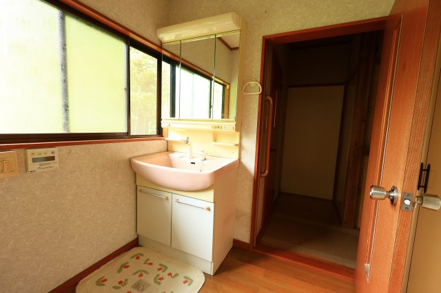 三面鏡付きの機能的な洗面化粧台。身支度に便利なシャワー水栓仕様です。大きな窓から自然光が入り、明るく清潔感のある洗面空間。脱衣スペースもしっかり確保されており、動線もスムーズです。