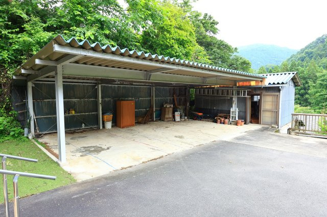 敷地内には、複数台の駐車が可能な鉄骨造りの大型車庫が完備されています。大切な愛車を雨風から守るだけでなく、趣味のガレージや作業スペース、農機具やアウトドア用品の保管場所としても最適です。