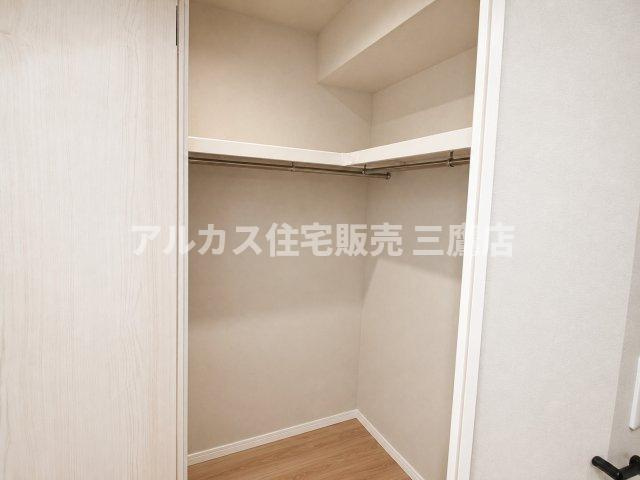 ハンガーパイプと上部棚を備え、衣類を効率よく整理できるウォークインクローゼット。